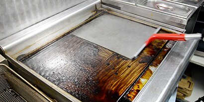 person using quick clean system in a commercial kitchen
