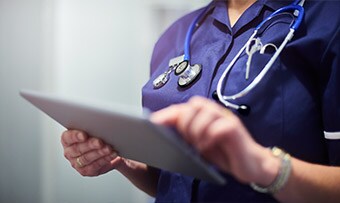 Clinician using a tablet to share resources with a patient
