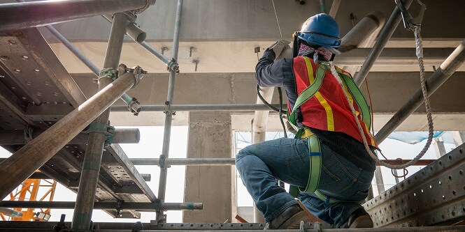Worker on construction project wearing safety gear.
