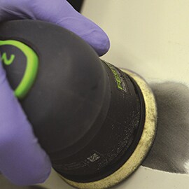 final sanding and inspection of damaged vehicle panel