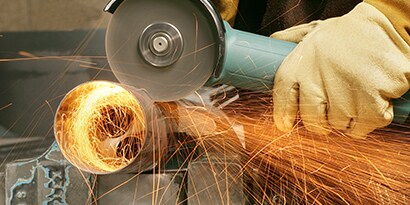 Cutting metal with a weld grinder in a shop 
