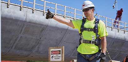 Worker in fall protection gear at construction site
