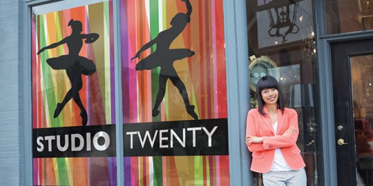 A woman leans against a storefront with large, bold window graphic film
