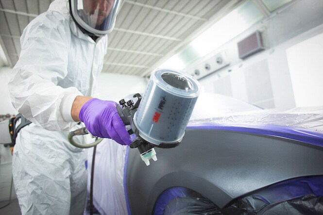 person using spray gun for painting cars
