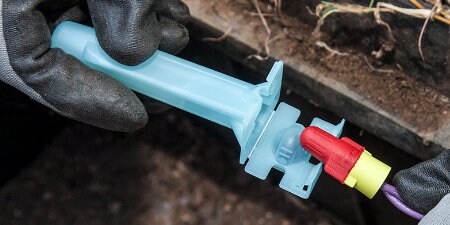 worker placing wire nut inside 3M Direct Bury Splice underground
