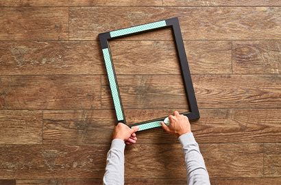 person using Scotch-Mount™ Indoor Double-Sided Mounting Tape