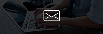 white envelope icon against a semi transparent black background showing hands on a laptop keyboard
