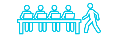 A group of people sitting at a desk with laptops
