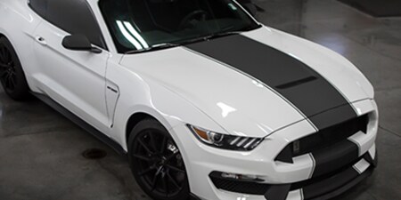 White car with black stripe accent, affordable lapping price with custom vehicle wrap design
