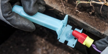 worker placing wire nut inside 3M Direct Bury Splice underground
