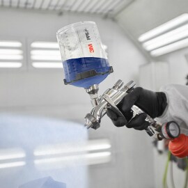 paint spray gun being used in paint booth