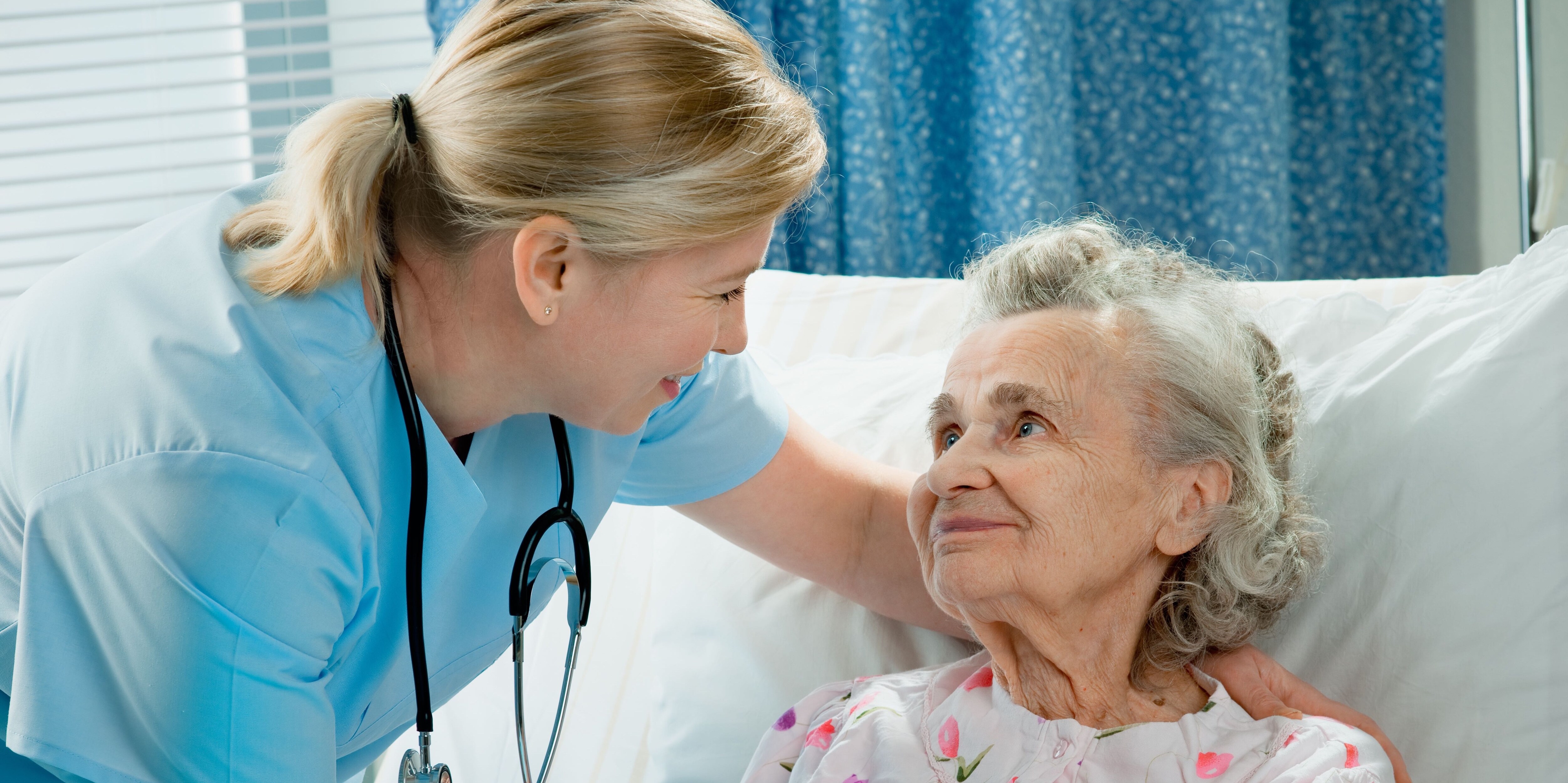 Healthcare worker smiling while attending a patient.
