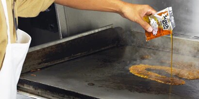 person cooking food on a grill
