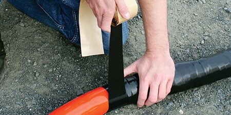 worker wrapping thick cable in 3M Electrical Tape
