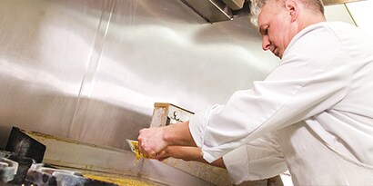 Man cleaning a griddle
