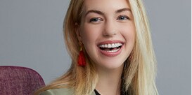 Woman smiling in chair to show 3M clear ceramic braces.

