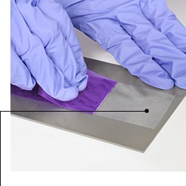 Gloved hands removing 3M™ Anodizing Masking Tape 8985L, leaving sharp masked lines and no residue 