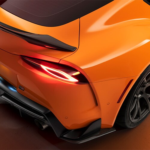 Detail of sports car rear passenger side of orange wrap film