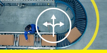 Top-down image of safety floor tape marking space around a U-bend conveyor with boxes; overlay of an icon representing flexibility
