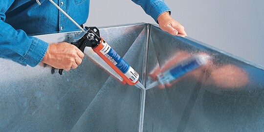 A person using a caulking object
