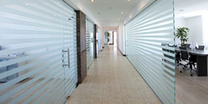 A long office hallway with glass graphic walls
