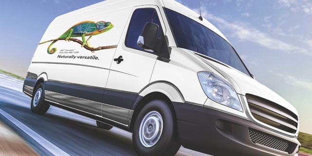  A big white van driving on a highway with a chameleon on the side of it using the 3M 48C graphic film.
