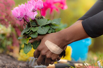 person gardening while wearing Nexcare™ bandage