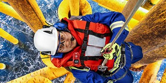 Worker hanging in safety harness over water wearing anti fog safety glasses
