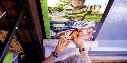 person measuring a picture of a child
