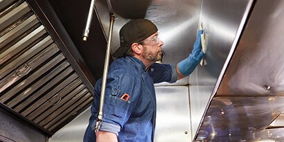 person cleaning a metal surface
