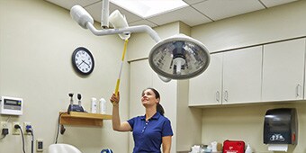 Facility worker cleaning a surgical suite
