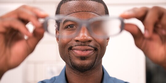 Man holding Scotchgard anti-fog safety glasses
