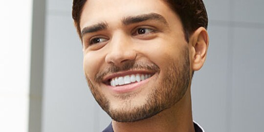 Man smiling wearing nearly invisible Clarity Aligners
